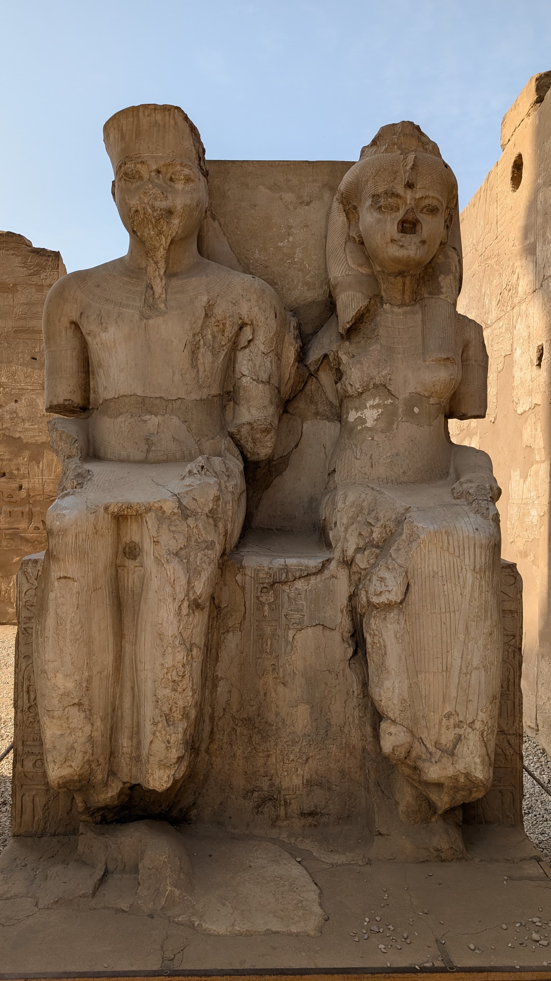 Seated double statue of pharaoh and consort in golden afternoon light, Luxor Temple