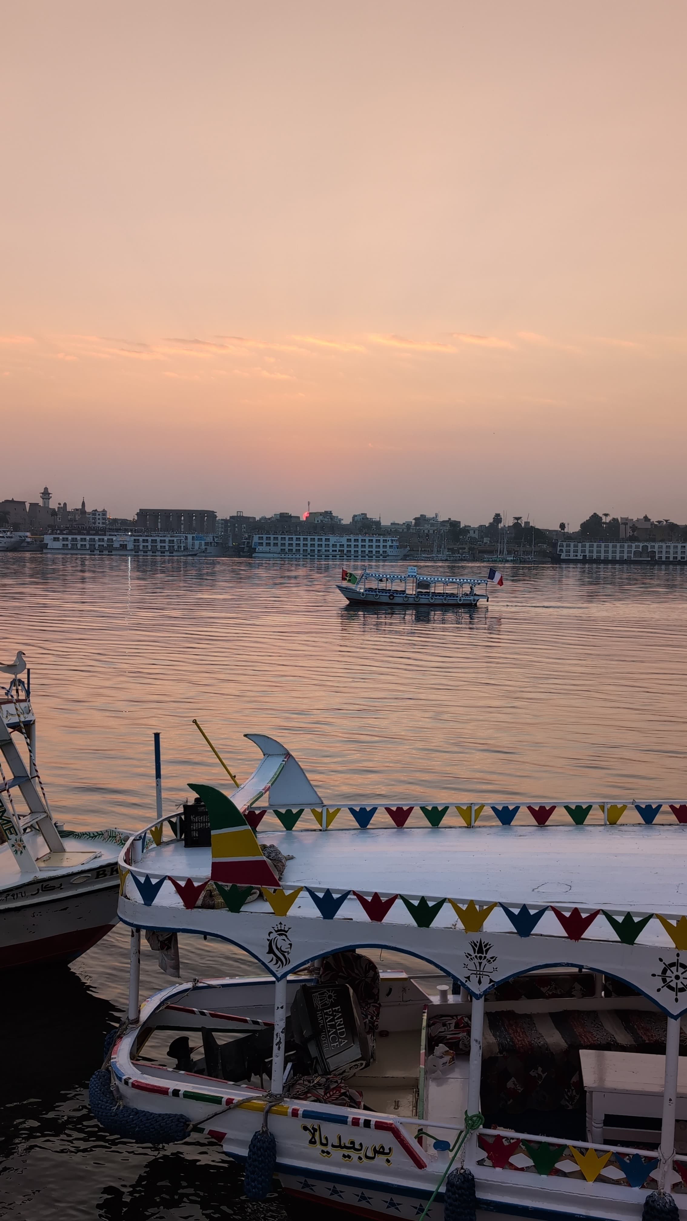 Nile at sunset with decorated felucca boats in the foreground, Luxor
