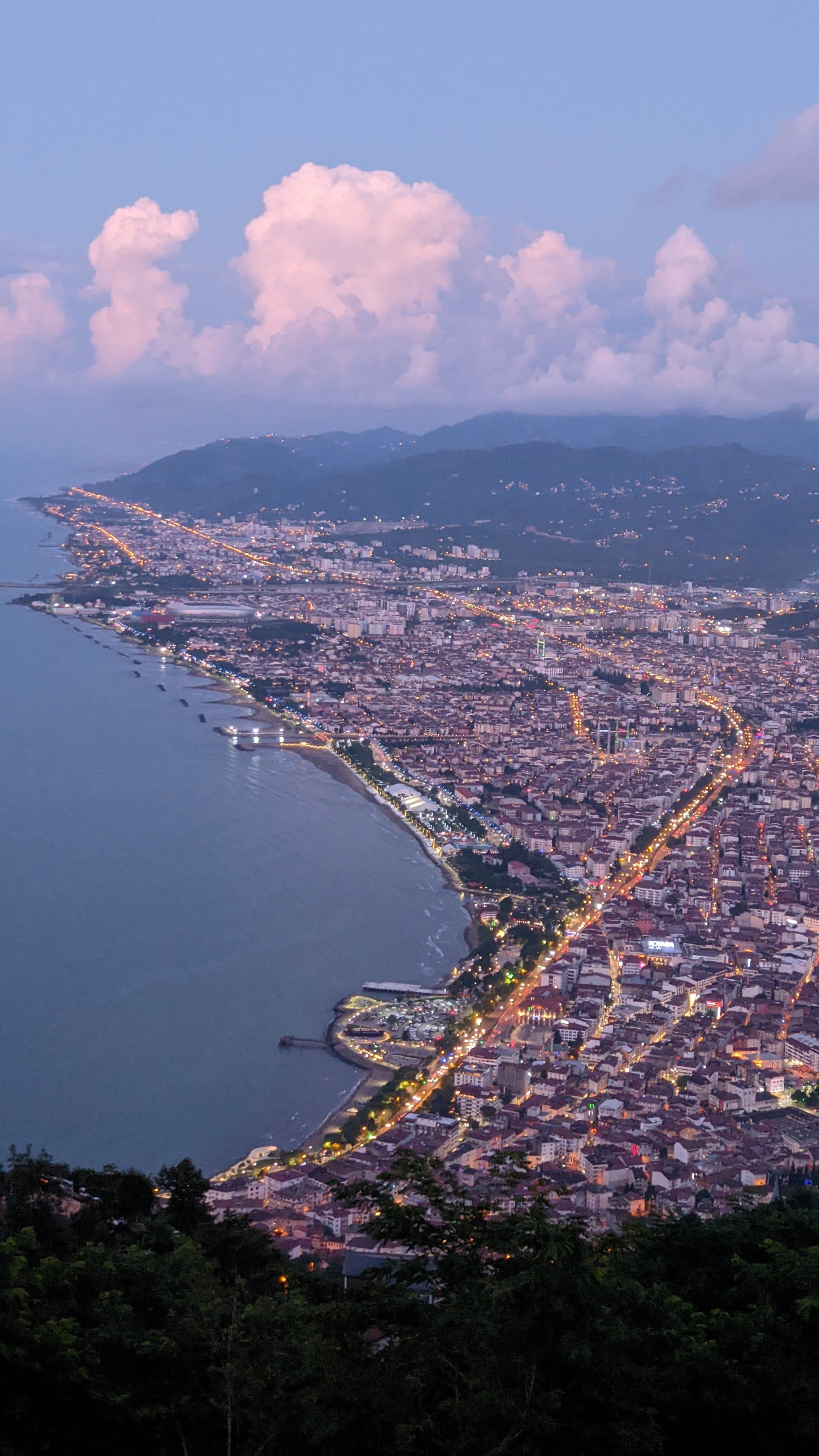 Twilight aerial of Ordu city cascading to coast with gold promenade lights