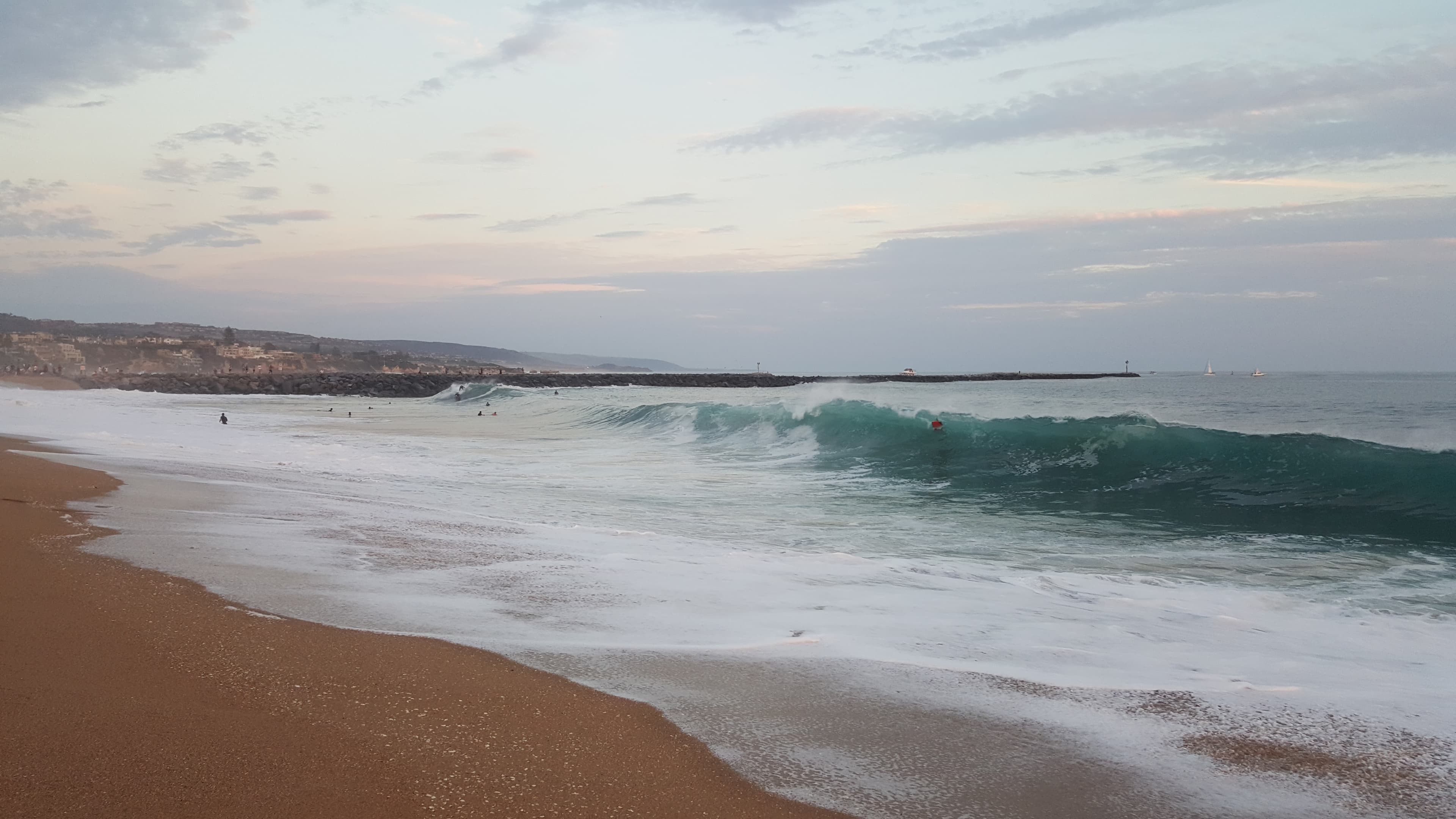 Newport Beach harbour with sailboats and residential houses along the waterfront at golden hour