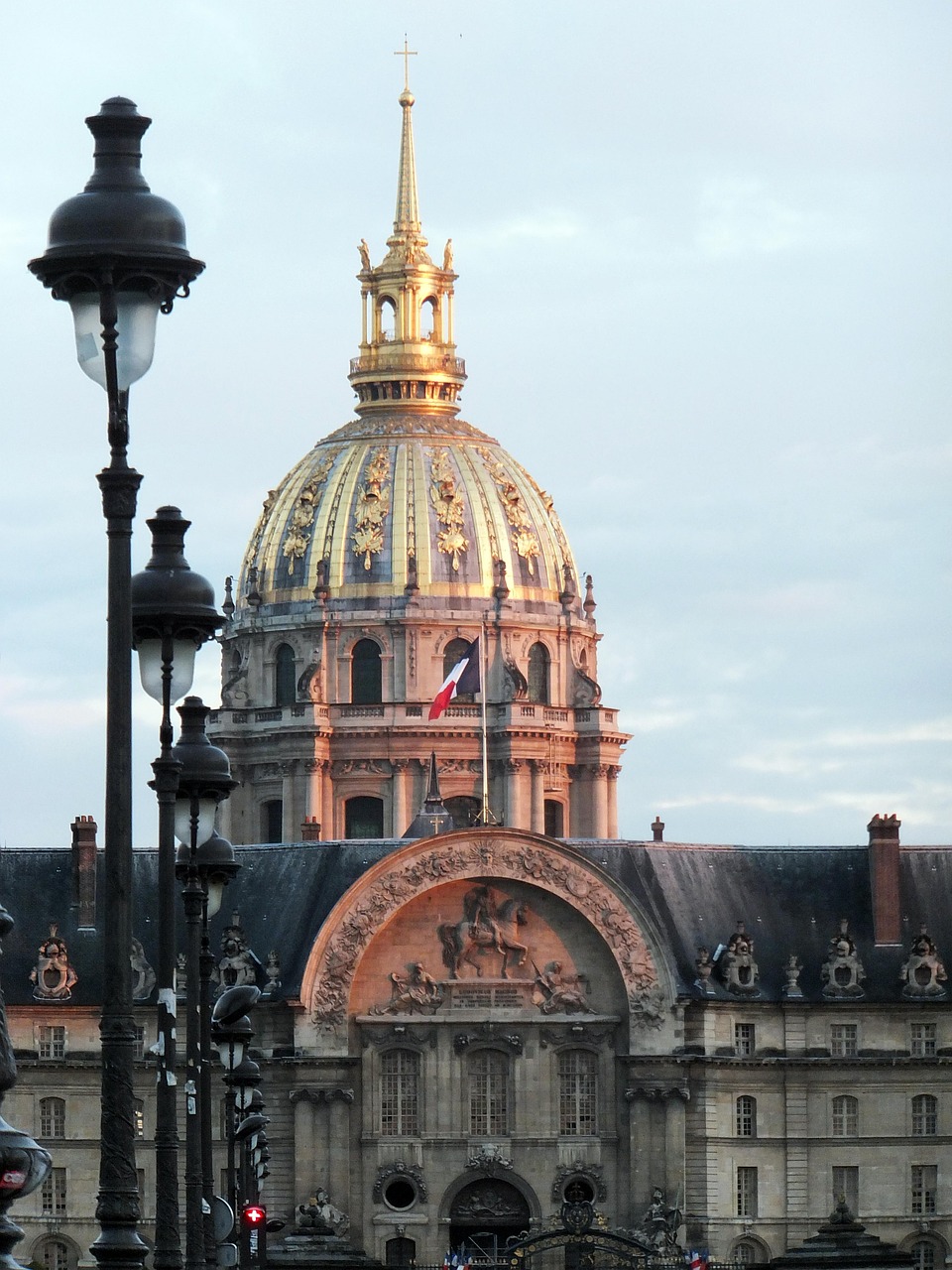 Les Invalides golden dome rising above the Paris roofline in soft morning light