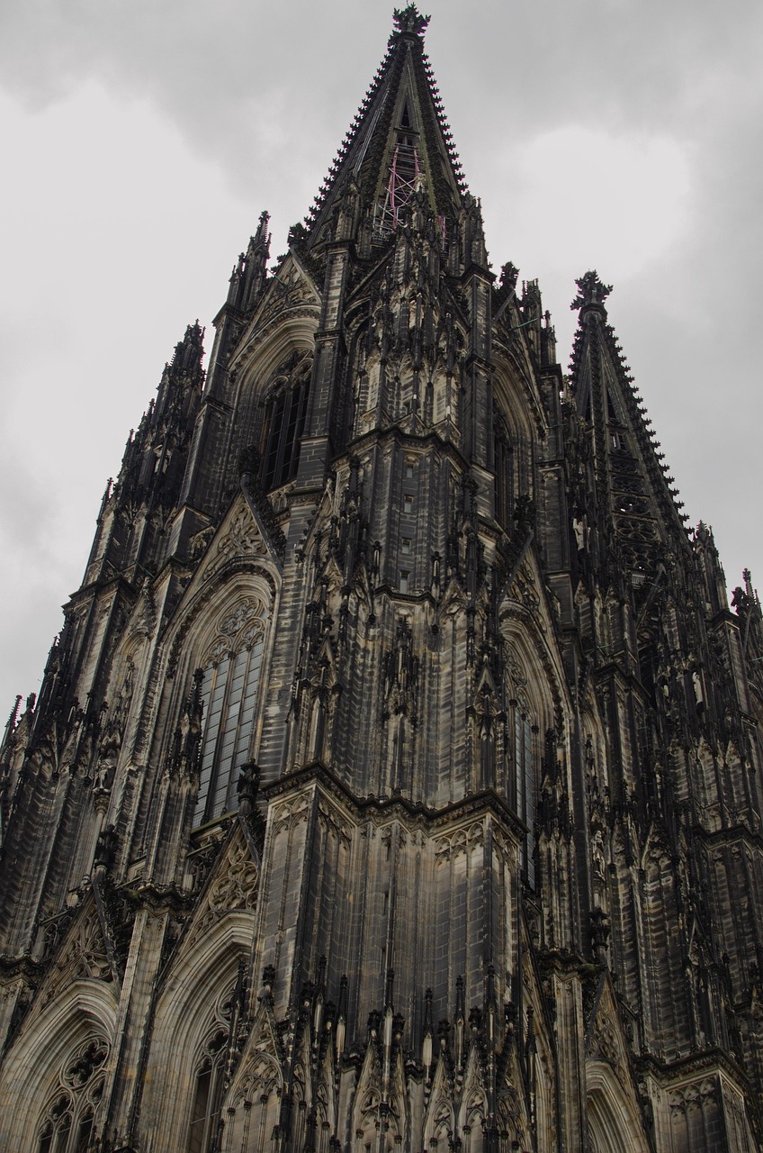 Cologne Cathedral twin spires seen from across the Rhine at dusk with the bridge in the foreground