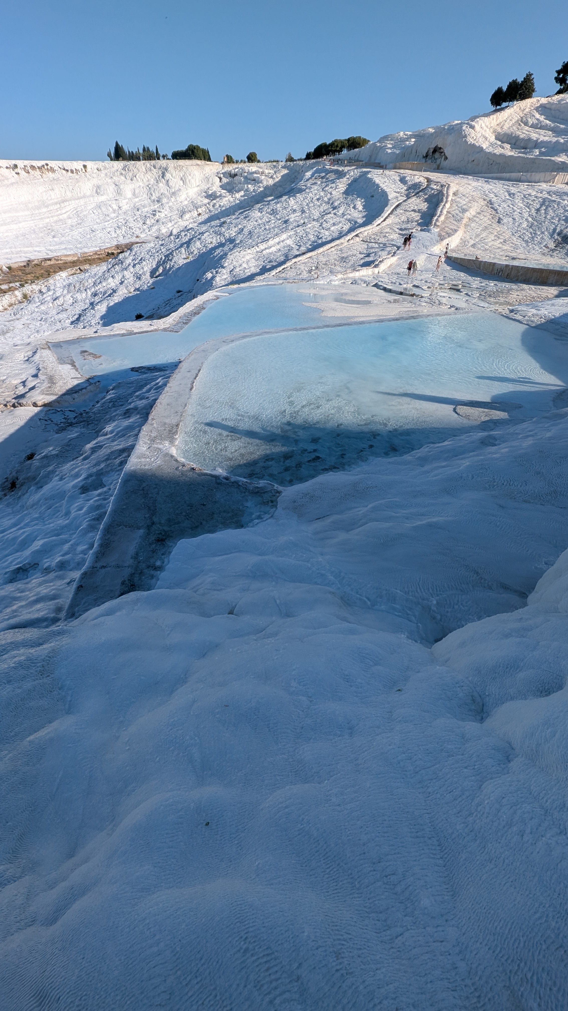 Pamukkale travertine terraces wide shot with sky and visitors