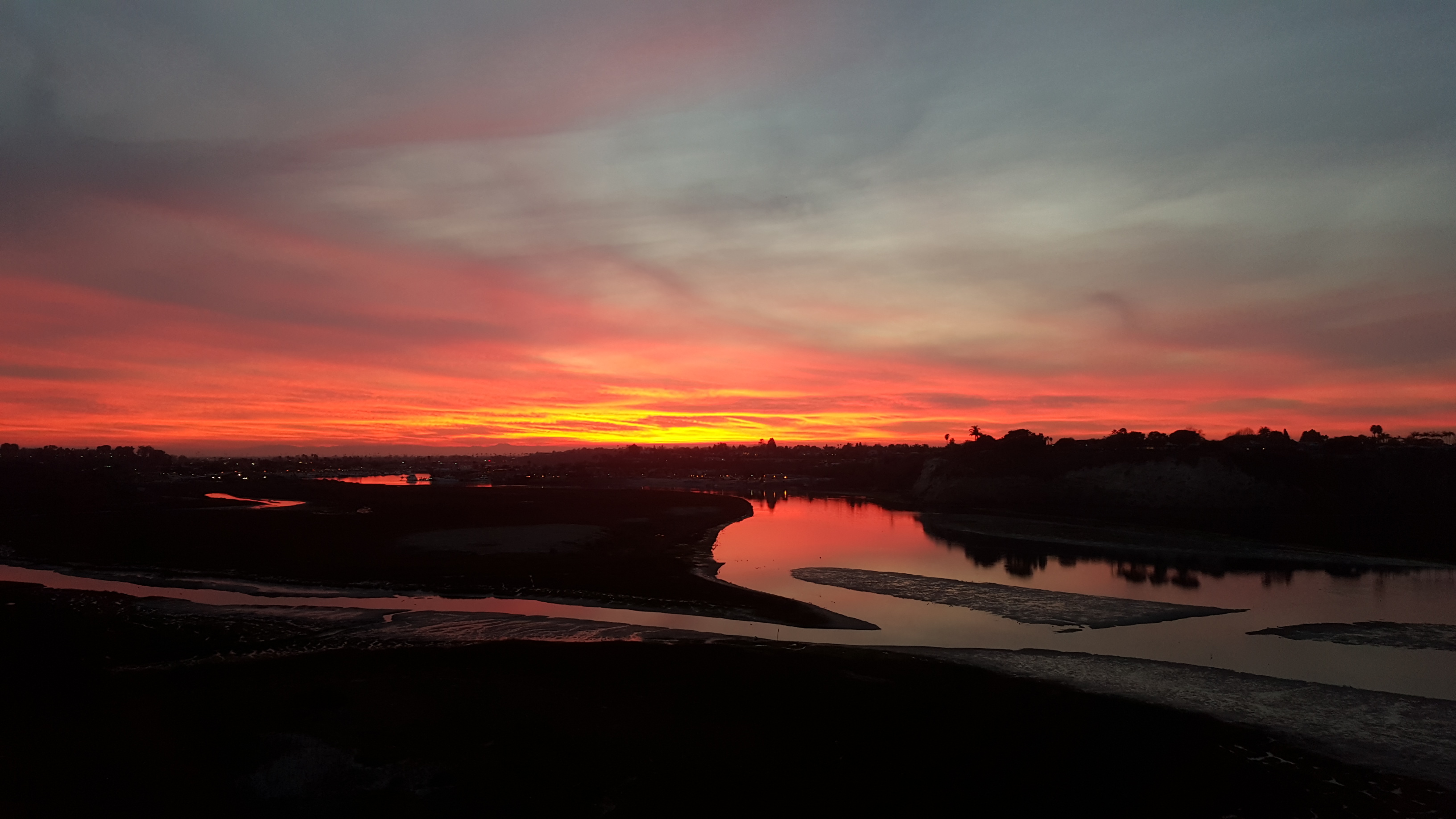 Newport Beach harbour with sailboats and the Balboa Peninsula at sunset